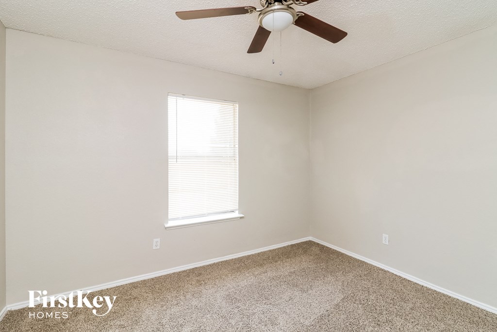 the bedroom of our studio apartment atrium with ceiling fan and carpet