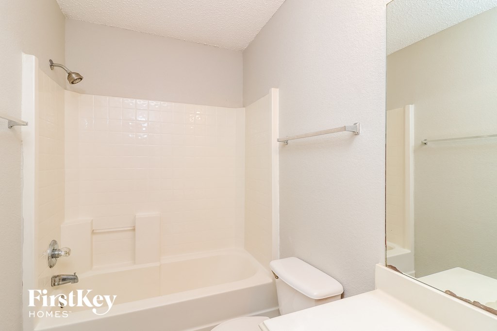 a white bathroom with a tub and toilet and a sink