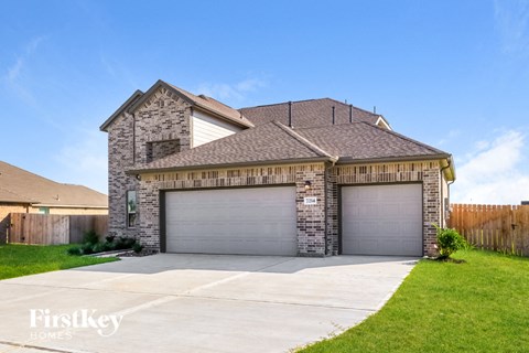 a house with two garages and a driveway in front of it