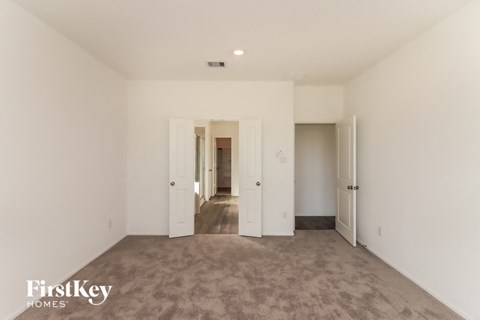 a living room with carpet and white walls and doors