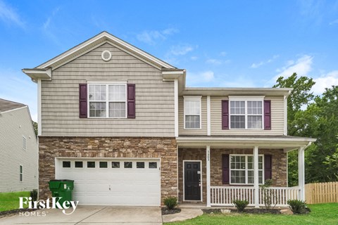 A two-story house with a garage and a porch.