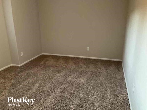a empty room with a carpeted floor and a white wall