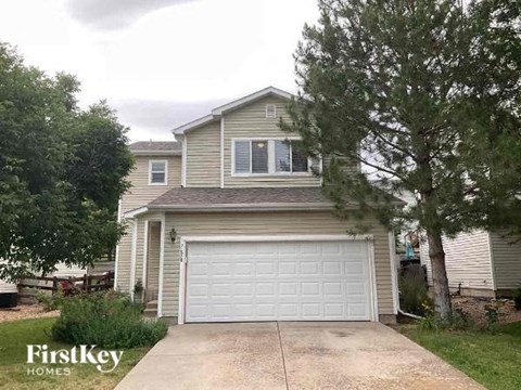 a tan house with a white garage door