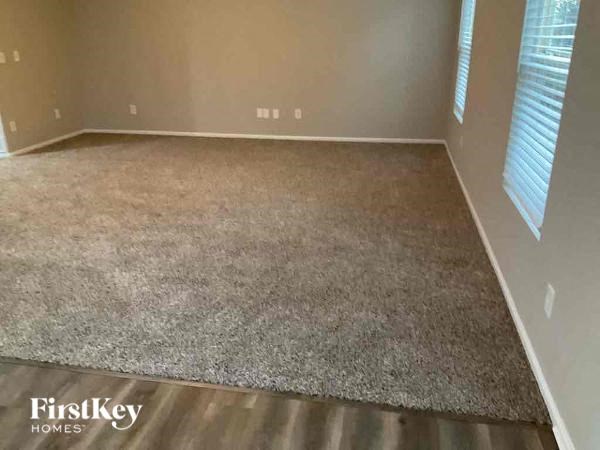 an empty living room with a rug on the floor
