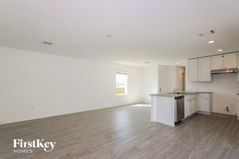 an empty kitchen and living room with white walls and wood floors