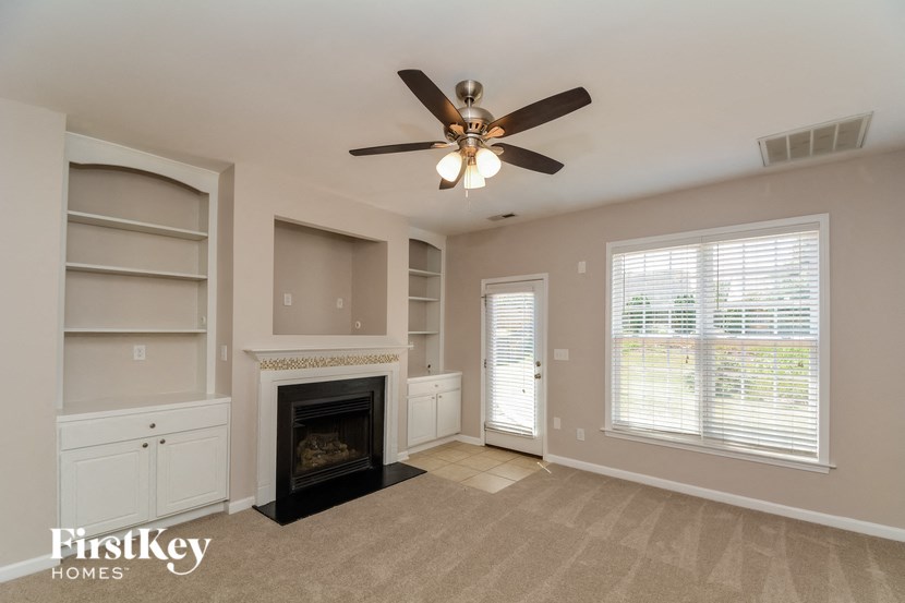 a living room with a fireplace and a ceiling fan