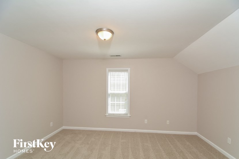 the second bedroom is spacious and light filled with carpet and a window