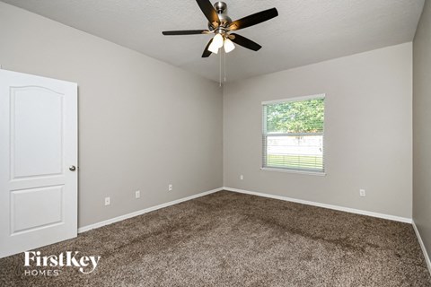 a bedroom with carpet and a ceiling fan