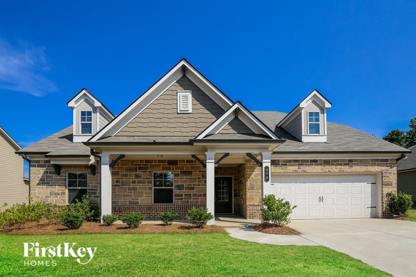 a large brick house with a garage and a lawn
