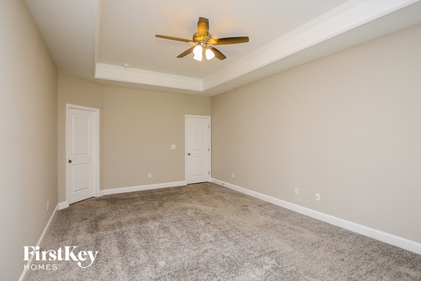 a empty living room with a ceiling fan