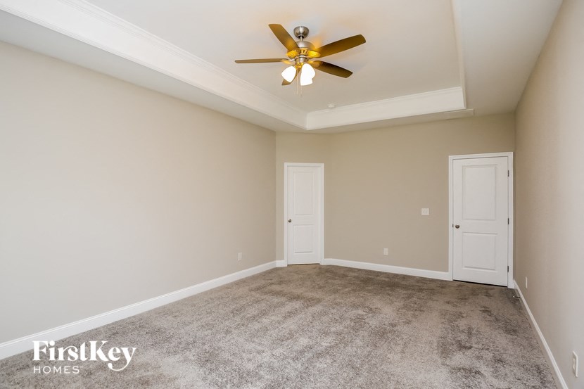 the living room of a home with carpet and a ceiling fan
