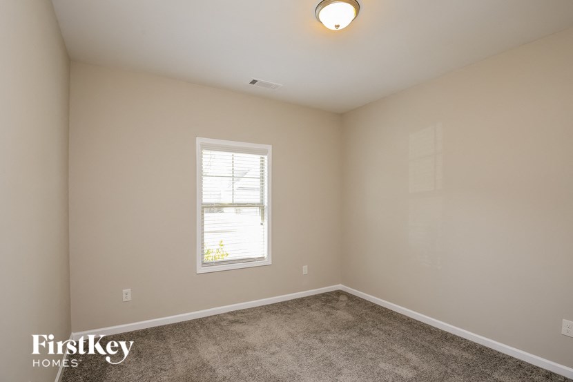 a bedroom with a carpeted floor and a window