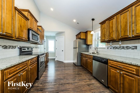 A kitchen with wooden cabinets and a FirstKey Homes logo.