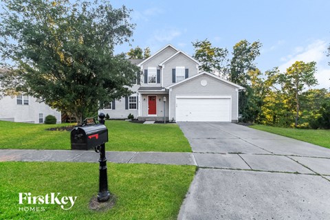 a white house with a red door and a mailbox on the sidewalk