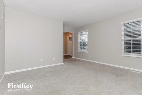 an empty living room with blinds on the window