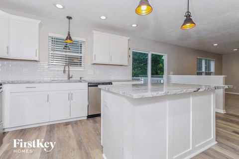 a white kitchen with white cabinets and a counter top