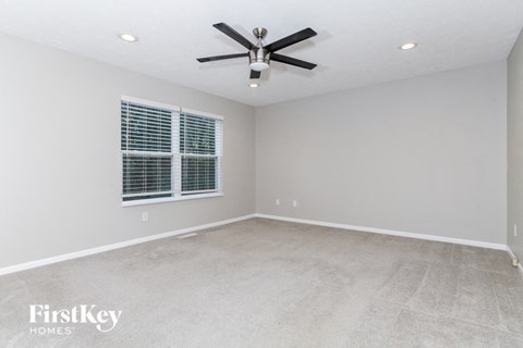 an empty room with a ceiling fan and a window