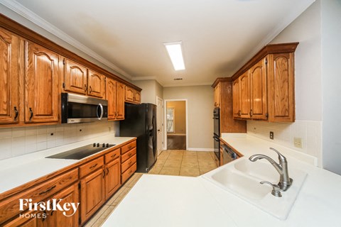 A kitchen with wooden cabinets and a white counter top.