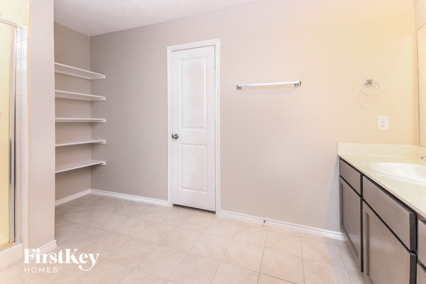 a bathroom with a sink and a closet with shelves
