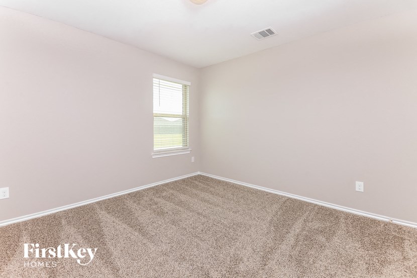 a bedroom with a carpeted floor and a window