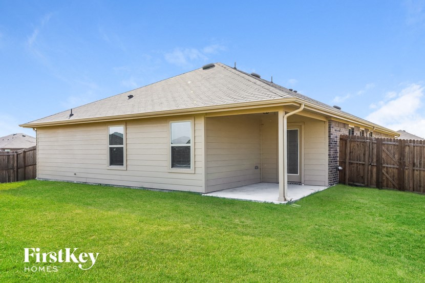 the backyard of a house with a lawn and a porch