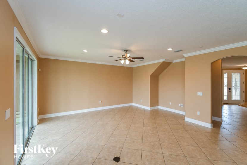 A spacious room with a ceiling fan and tiled floor.