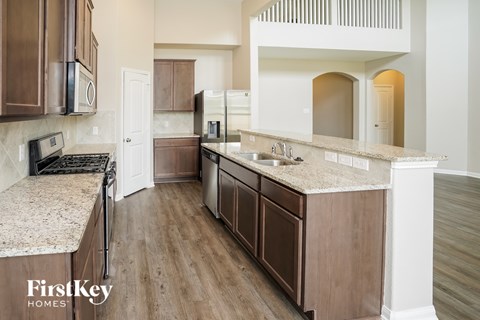 A kitchen with wooden cabinets and a granite countertop.