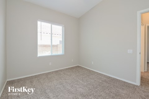a bedroom with a carpeted floor and a window