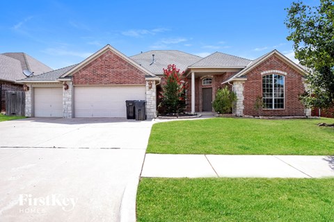 a brick house with a garage and a lawn