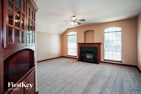 an empty living room with a fireplace and a cabinet