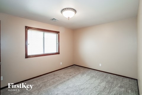 a bedroom with a window and a carpeted floor