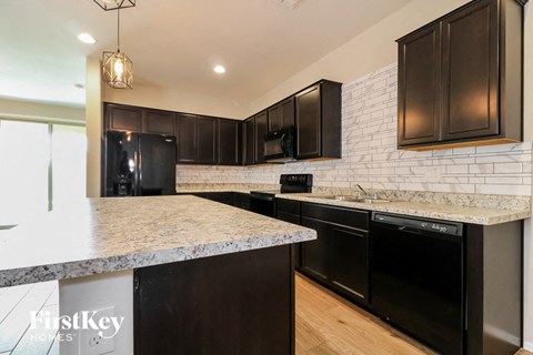 a kitchen with black appliances and granite counter tops