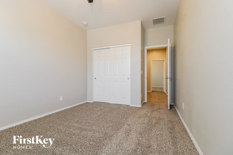 a bedroom with a white door and a carpeted floor