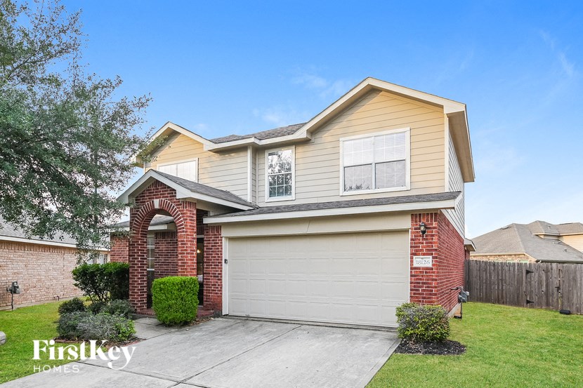 a beige and brick house with a garage door