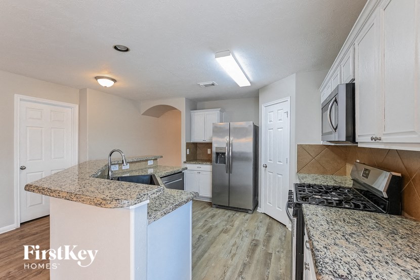 a kitchen with granite counter tops and a stainless steel refrigerator