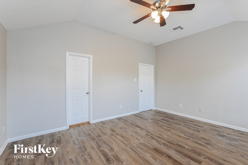 the living room of an empty home with a ceiling fan