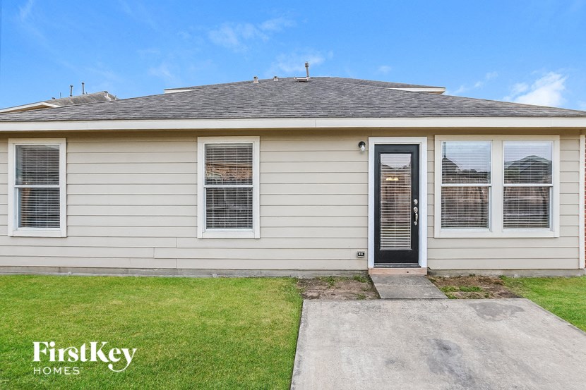 the front of a white house with a black door