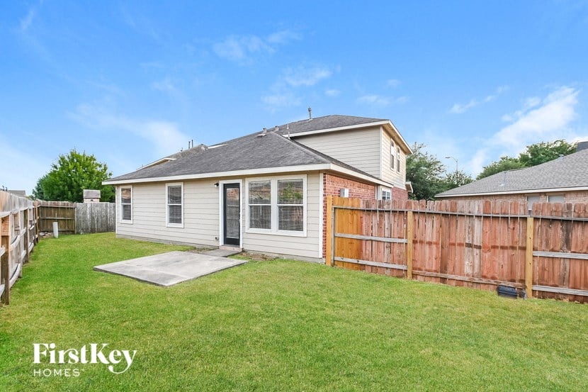 a backyard with a house and a wooden fence