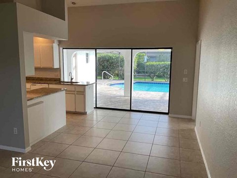 A kitchen area with a pool in the backyard.