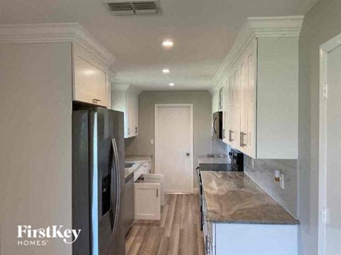 a kitchen with white cabinets and a stainless steel refrigerator