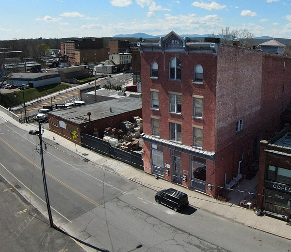 an aerial view of a brick building on a city street