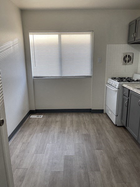 an empty kitchen with a stove and a window