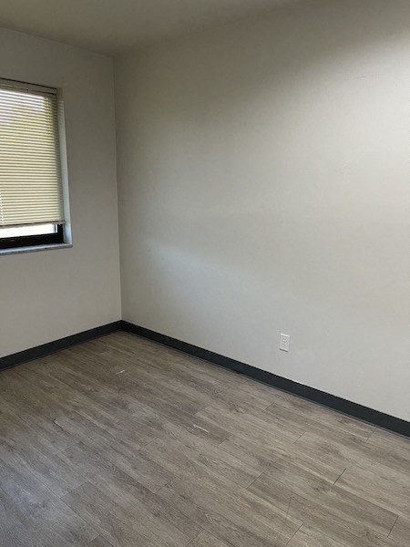 an empty room with a window and wooden floors