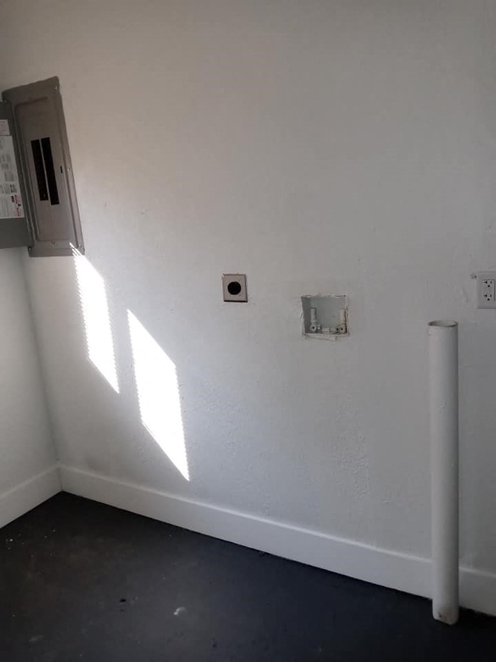 a white wall with two outlets and a door