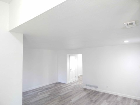 a living room with white walls and wood floors