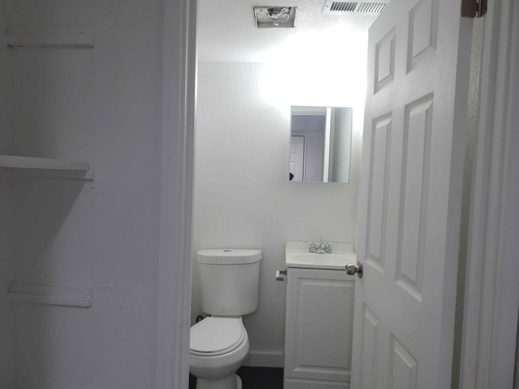 a white bathroom with a toilet and a sink