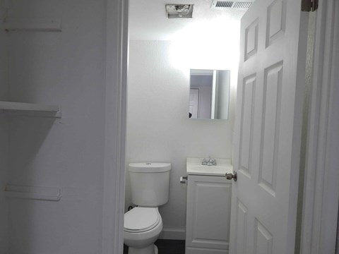a white bathroom with a toilet and a sink