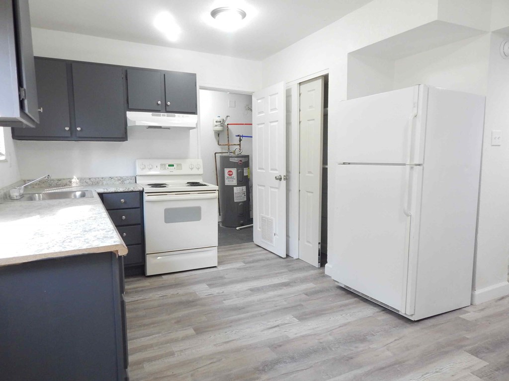 a renovated kitchen with white appliances and black cabinets