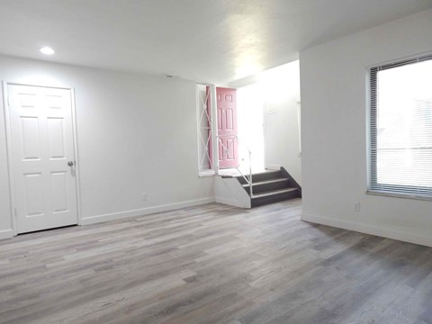 an empty living room with white walls and wood floors