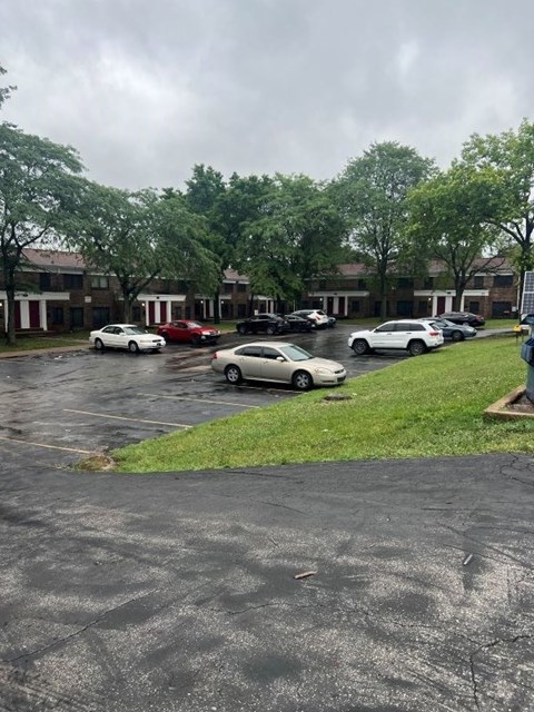 A parking lot with cars and a building in the background.